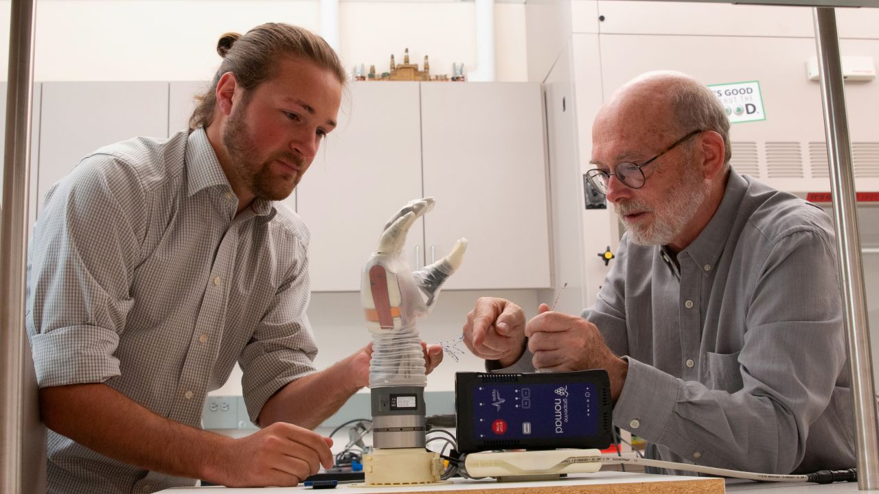 University of Utah biomedical engineering doctoral student Jacob George, left, and associate professor Gregory Clark, are helping develop a prosthetic arm that can move via the wearer's thoughts as well as feel the sensation of touch to make it easier to pick up and hold objects.