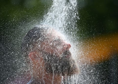 A man cools down at an outdoor pool's shower in Baden-Wuerttemberg, Germany, on Thursday, July 25.