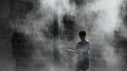 TOPSHOT - A boy cools off under a public water spray on the bank of the Seine river in Paris on July 25, 2019 as a new heatwave hits Europe. - After all-time temperature records were smashed in Belgium, Germany and the Netherlands on July 24, Britain and the French capital Paris could on July 25 to see their highest ever temperatures (Photo by Philippe LOPEZ / AFP)        (Photo credit should read PHILIPPE LOPEZ/AFP/Getty Images)