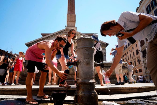 People collect water from the public fountain in front of the Pantheon in Rome on Thursday, July 25.