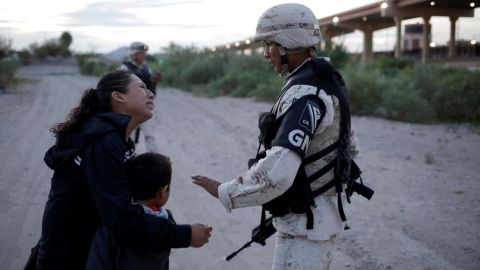 Lety Perez embraces her son, Anthony, while asking a member of the Mexican National Guard to let them cross into the United States.