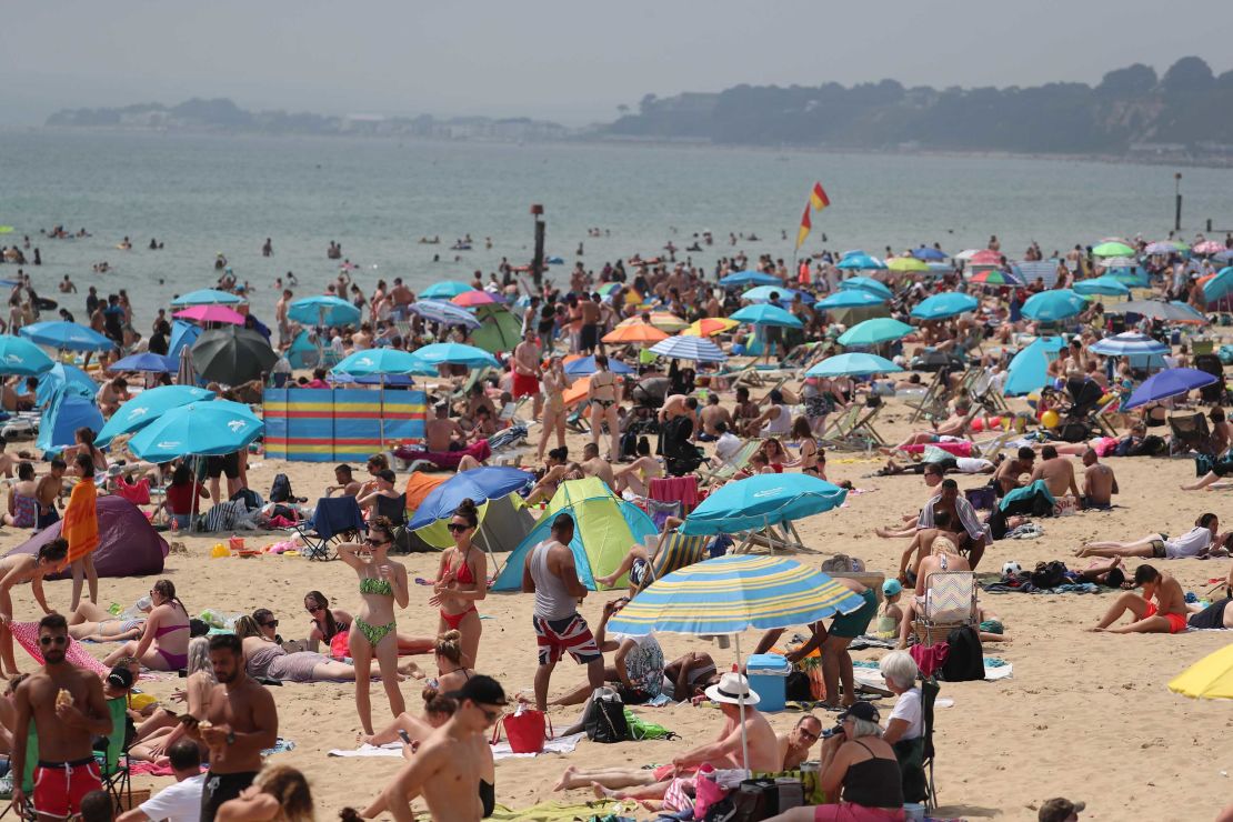 People enjoy the hot weather at a beach in Bournemouth, UK.