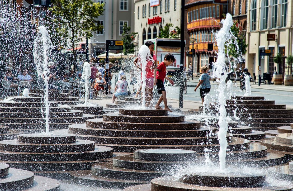 People cool off in the fountains in Aalborg, Denmark, on July 24, 2019.