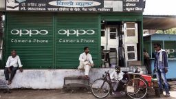 People rest outside a shuttered store displaying an advertisement for smartphone maker Oppo Electronics Corp. in Gwalior, Madhya Pradesh, India, on Friday, June 2, 2017. India's rates traders seem convinced record-low inflation and an unexpected slowdown in economic growth will prompt the central bank to soften its hawkish stance when its announces a policy decision Wednesday. Photographer: Udit Kulshrestha/Bloomberg via Getty Images