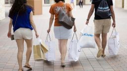 Pedestrians carry shopping bags while walking through the Grand Prairie Premium Outlets mall in Grand Prairie, Texas, U.S., on Monday, May 23, 2016. The Bloomberg Consumer Comfort Index, a survey which measures attitudes about the economy, is scheduled to be released on May 26. Photographer: Laura Buckman/Bloomberg via Getty Images