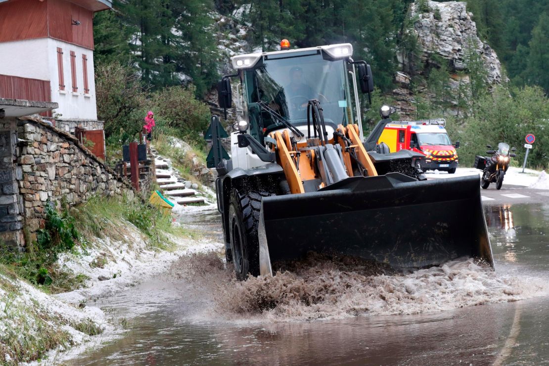 A worker uses a digger to clean the road of the nineteenth stage of the Tour de France.