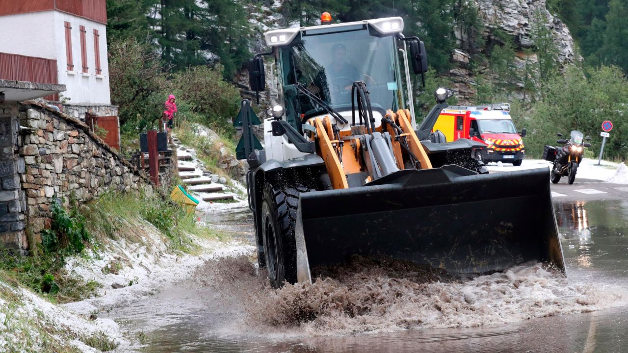 A worker uses a digger to clean the road during the 19th stage of the Tour de France. Race organizers stopped the race because of a hail storm as Julien Alaphilippe lost his yellow jersey to Egan Bernal.