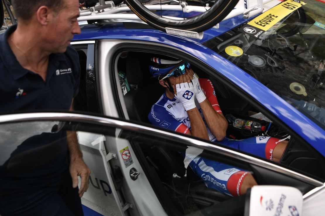 France's Thibaut Pinot, in his team car, reacts after quitting the Tour de France.