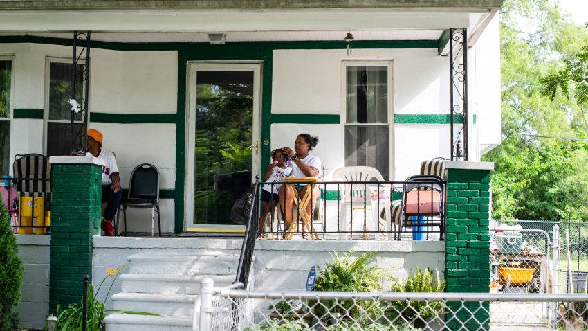 DETROIT, MICHIGAN - July 24, 2019: Crystal Daniels, 31, and her daughter Mikayla Daniels, 3, gaze out at passing car while hanging out on their front porch with Crystal's father Wayne Daniels, 59, in their neighborhood in the west side of Detroit, Mich., on Tuesday, July 23, 2019. Mr. Daniels has lived in the neighborhood for over 30 years. (Brittany Greeson for CNN)