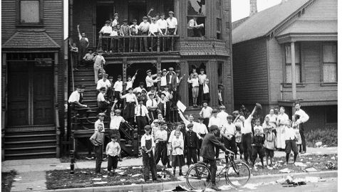 In this 1919 photo provided by the Chicago History Museum, a crowd gathers at a house that has been vandalized and looted during the race riots in Chicago. Some of the crowd is posing inside broken windows, others are standing on the lawn.