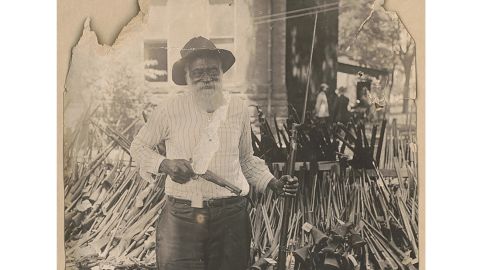 In this July 13, 1919 image provided by the Library of Congress, Daniel Hoskins stands with guns deposited at Gregg County Courthouse, in Longview, Texas, following race riots during Red Summer.
