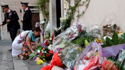 A woman leaves flowers in front of the police station where Mario Cerciello Rega was based in Rome, the day following his murder. 