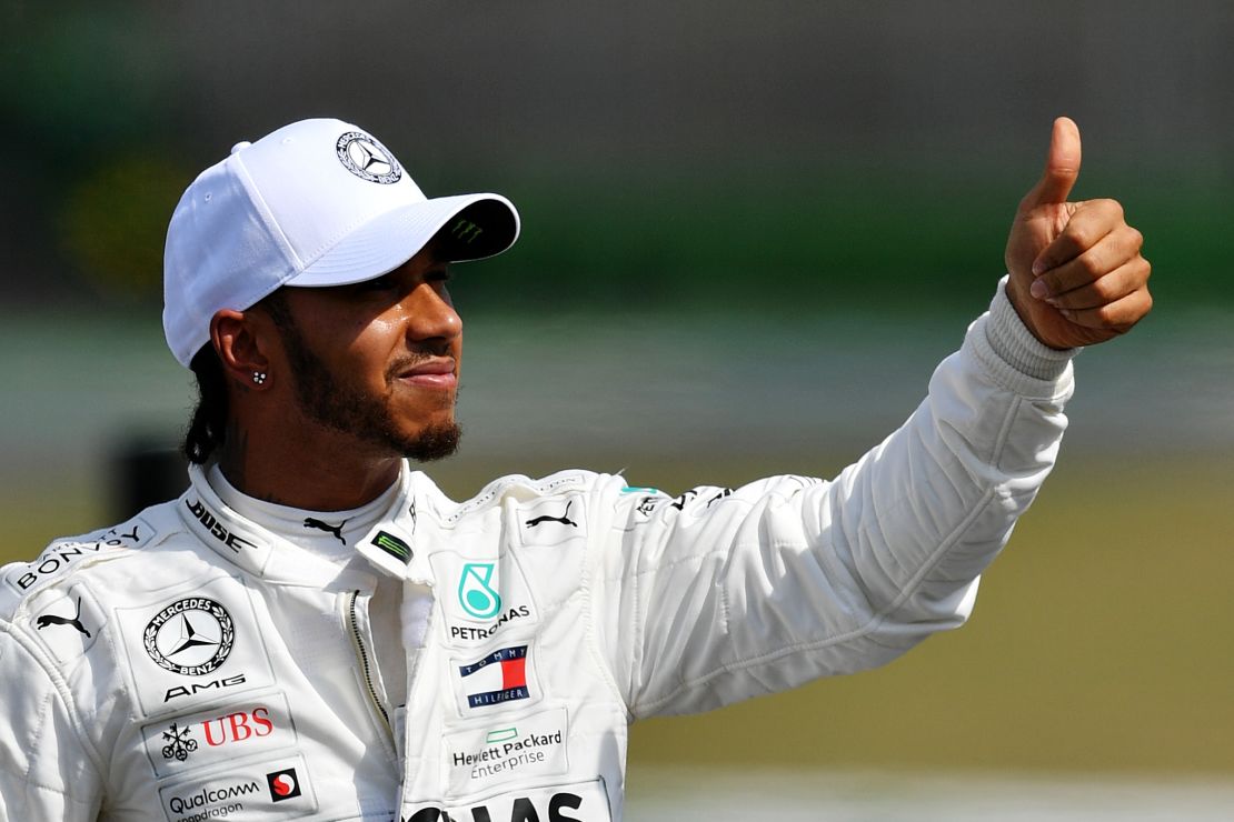 Lewis Hamilton of Great Britain and Mercedes GP waves to the crowd after securing pole position.