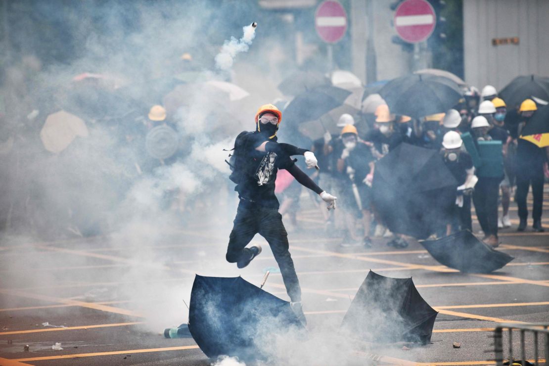 A protester throws tear gas back at police officers during a demonstration in the district of Yuen Long in Hong Kong on July 27, 2019. 