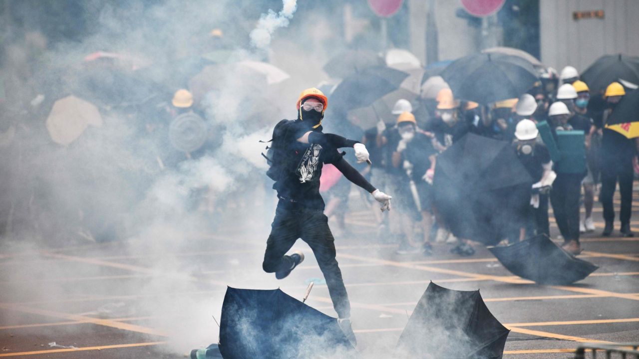 A protester throws tear gas back at police officers during a demonstration in the district of Yuen Long in Hong Kong on July 27, 2019.