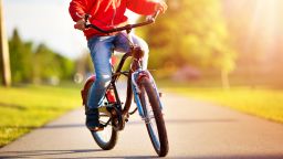 child on a bicycle at asphalt road in early morning; Shutterstock ID 705535063; Job: -