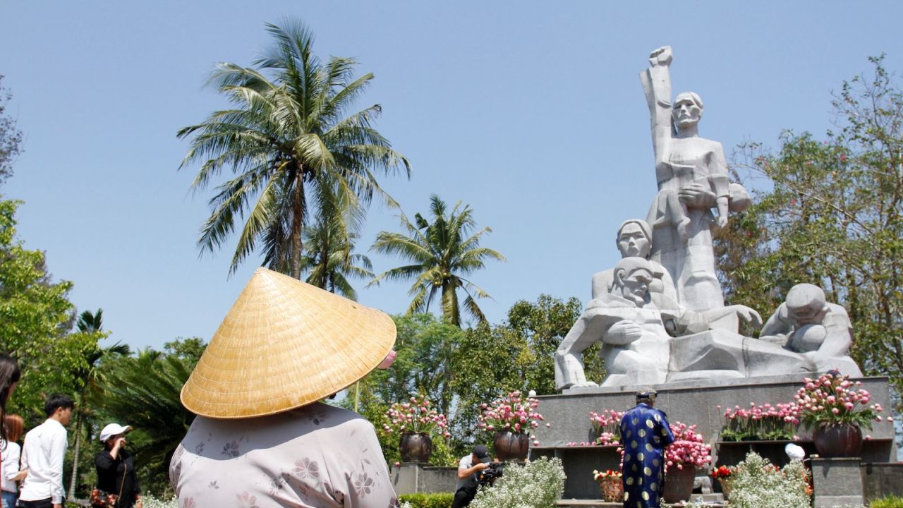 Visitors offer flowers at a war memorial dedicated to the victims of the My Lai massacre in the village of Son My during a ceremony marking the 50th anniversary of the massacre on March 16, 2018.