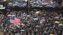 Protesters carry U.S. flags and placards during a protest march in Hong Kong, Sunday, July 28, 2019. A sea of black-shirted protesters, some with bright yellow helmets and masks but many with just backpacks, marched down a major street in central Hong Kong on Sunday in the latest rally in what has become a summer of protest. (AP Photo/Vincent Yu)