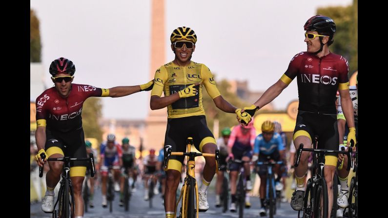 Jonathan Castroviejo, left, and Geraint Thomas, right, congratulate Egan Bernal as he celebrates winning the 106th <a href="index.php?page=&url=https%3A%2F%2Fwww.cnn.com%2F2019%2F07%2F28%2Fsport%2Ftour-de-france-bernal-colombia-spt-intl%2Findex.html" target="_blank">Tour de France</a> in Paris, on Sunday, July 28. Bernal is the first rider from Colombia to win the Tour.