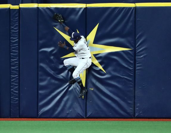 Tampa Bay Rays left fielder Guillermo Heredia runs into the outfield wall while attempting to catch a home run hit by Boston Red Sox first baseman Sam Travis during a baseball game in St. Petersburg, Florida, on Monday, July 22.
