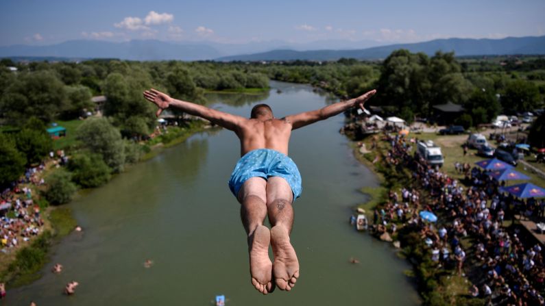 A man jumps from a 22-meter (72-foot) high bridge during the annual traditional high-diving competition near the town of Gjakova, Kosovo, on July 22.