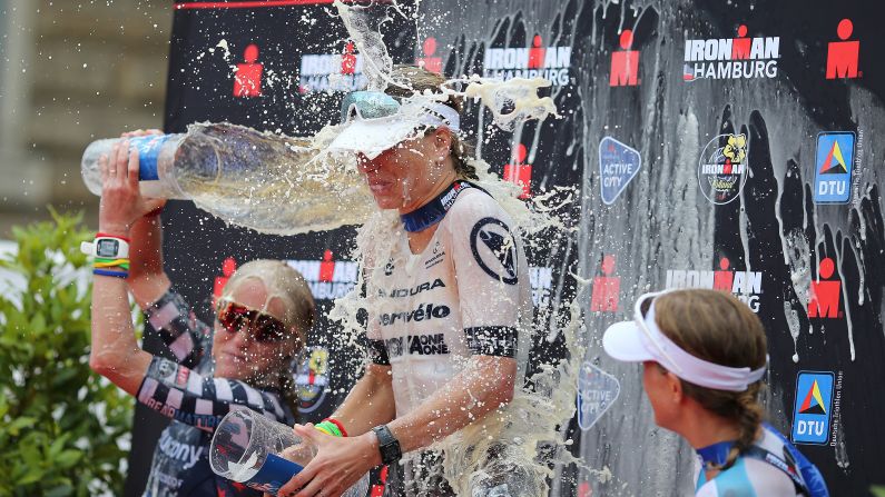 Sarah Piampiano of the United States, left, dumps beer on Susie Cheetham of Great Britain while celebrating on the podium of the Ironman Hamburg in Hamburg, Germany, on Sunday, July 28.