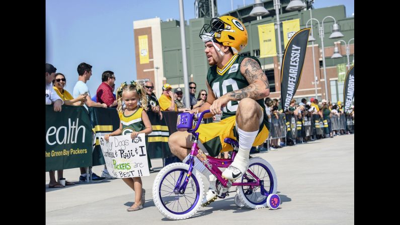Green Bay Packers linebacker Curtis Bolton rides a kid's bicycle to the first day of training camp in Green Bay, Wisconsin, on Thursday, July 25.