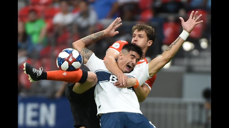 Cavalry FC defender Mason Trafford, right, holds Vancouver Whitecaps forward Joaquin Ardaiz during the second half of a soccer match at BC Place Stadium in Vancouver, Canada, on July 24.