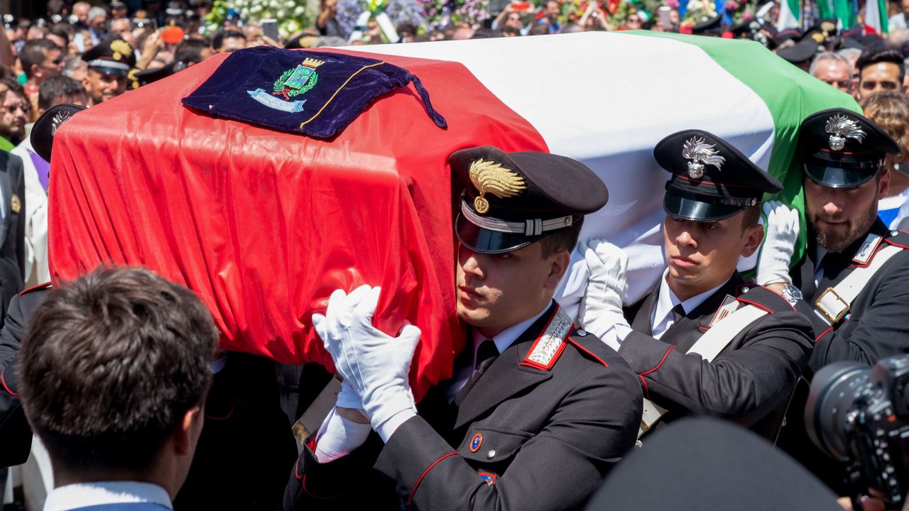 Rega's coffin was draped with the Italian flag. His funeral was attended by hundreds of mourners.