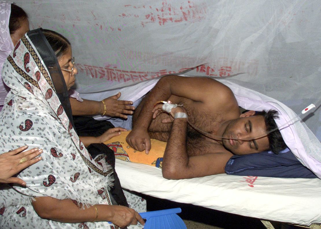 Relatives visit a victim of dengue fever at a hospital in Dhaka on
August 20, 2002. REUTERS/Rafiqur Rahman

