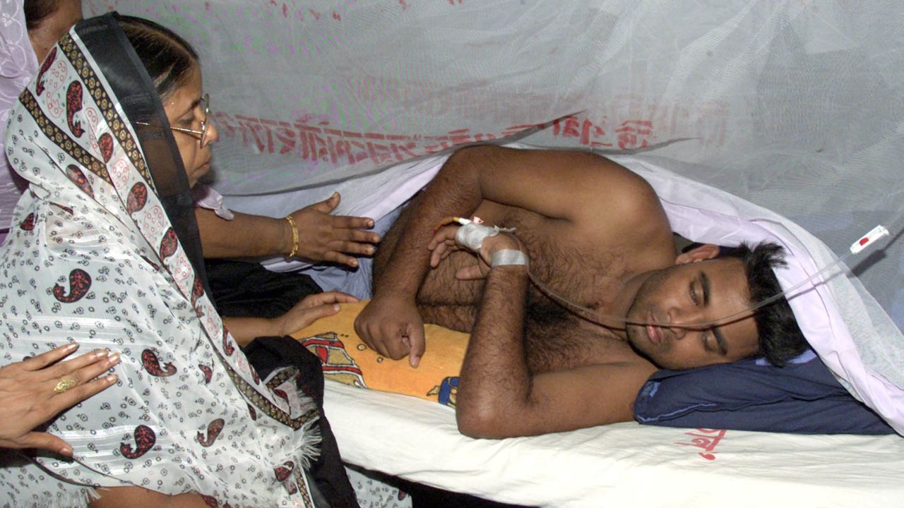 Relatives visit a victim of dengue fever at a hospital in Dhaka on
August 20, 2002. REUTERS/Rafiqur Rahman
