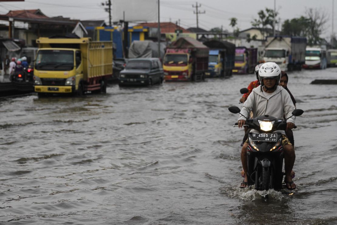 Vehicles in a flood caused by rising sea levels on a highway in Central Java, Indonesia on February 2.