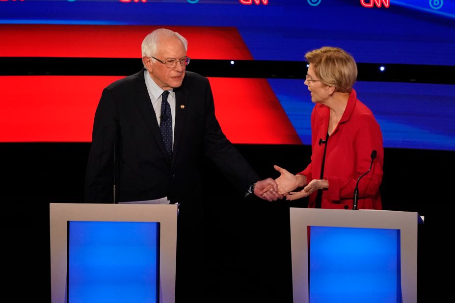 Sanders grabs the hand of US Sen. Elizabeth Warren during the Democratic debates in Detroit in July 2019.