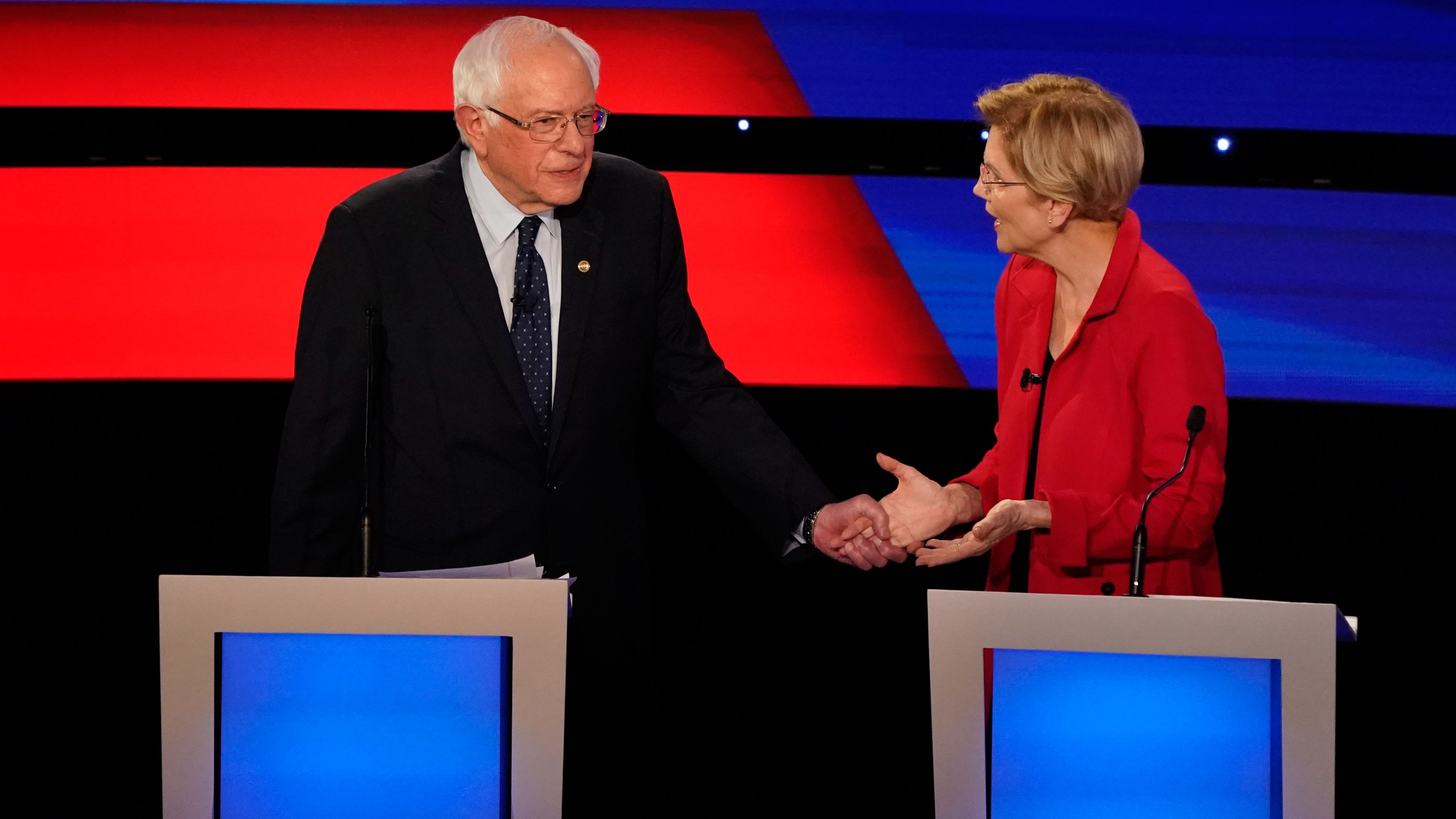 Sanders grabs the hand of US Sen. Elizabeth Warren during the Democratic debates in Detroit in July 2019.