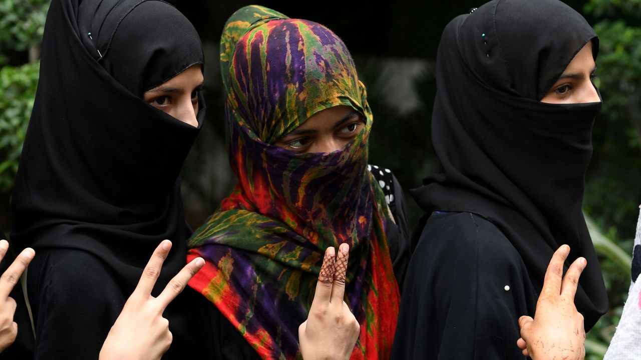 Muslim women pose with a gesture as they celebrate the passage of a law to outlaw Triple Talaq, or "instant divorce," at an event organised by the ruling Bharatiya Janata Party in New Delhi on July 31, 2019.