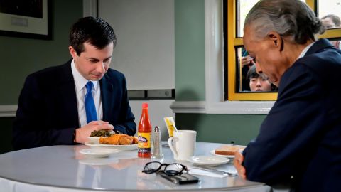 Buttigieg and civil rights leader Rev. Al Sharpton pray before a lunch meeting at Sylvia's Restaurant on April 29, 2019 in New York City. 
