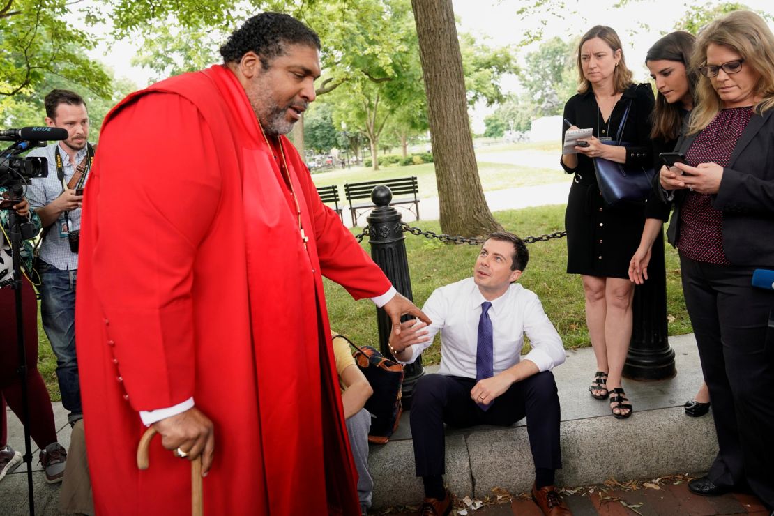 Buttigieg greets the Rev. William Barber as he attends a protest against the Trump administration in front of the White House on June 12, 2019. 