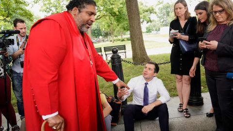 Buttigieg greets the Rev. William Barber as he attends a protest against the Trump administration in front of the White House on June 12, 2019. 