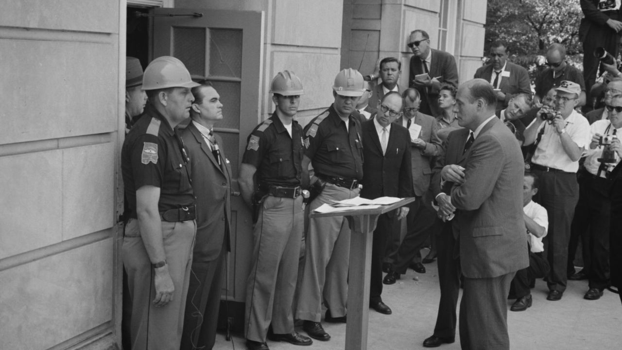 George Wallace attempting to block integration at the University of Alabama, standing defiantly at a door while being confronted by US Deputy Attorney General Nicholas Katzenbach, on June 11, 1963. 