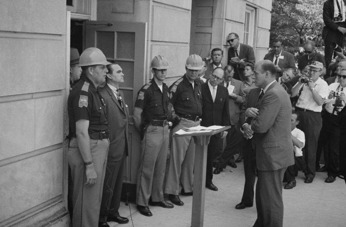 George Wallace attempting to block integration at the University of Alabama, standing defiantly at a door while being confronted by US Deputy Attorney General Nicholas Katzenbach, on June 11, 1963. 