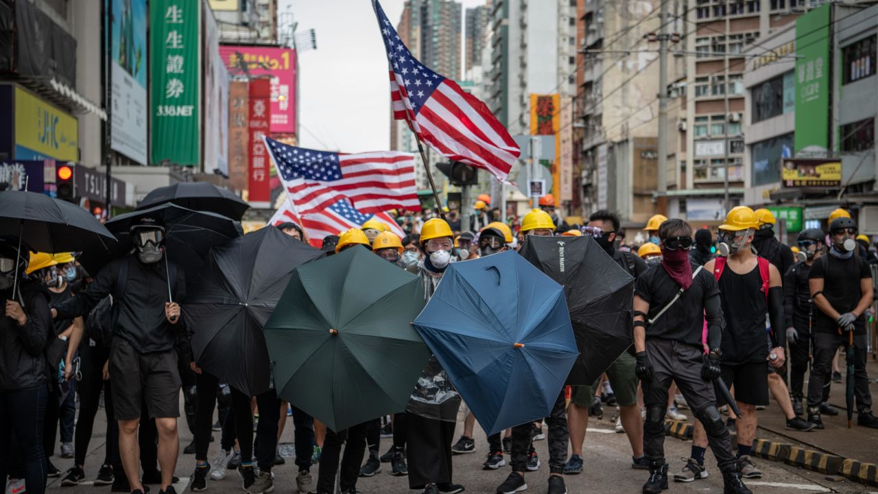 Protesters hold up umbrellas and American flags in the face of advancing riot police in the district of Yuen Long on July 27.