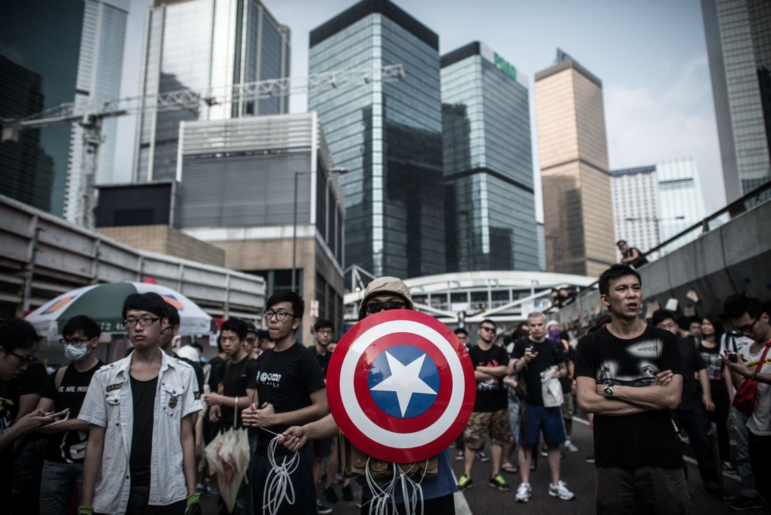 Pro-democracy protesters, including one carrying a shield from the "Captain America" comic book series stand their ground during protests in Hong Kong on October 4, 2014.