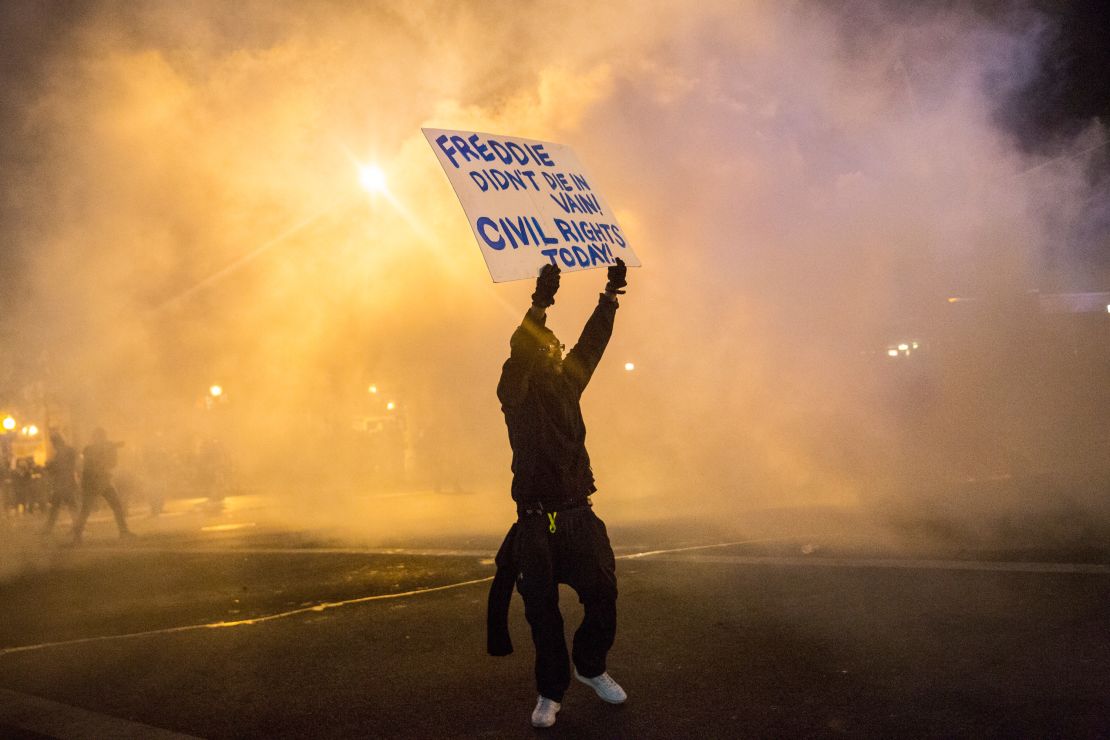 A protester walks through tear gas on April 28, 2015, as police enforce a curfew after the funeral of Freddie Gray in Baltimore.
