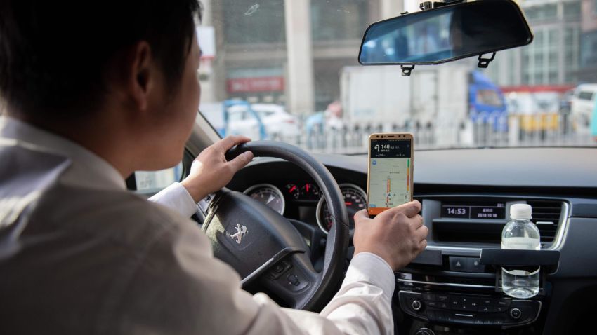 A driver working for ride-sharing company Didi follows a map on his smartphone to bring a customer to his destination in Beijing in October 2018.