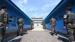TOPSHOT - South Korean soldiers (front) and North Korean soldiers (rear) stand guard before the military demarcation line on the each side of the truce village of Panmunjom in the Demilitarized zone (DMZ) dividing the two Koreas on April 26, 2018 ahead of the inter-Korea summit. (Photo by - / Korea Summit Press Pool / AFP)        (Photo credit should read -/AFP/Getty Images)