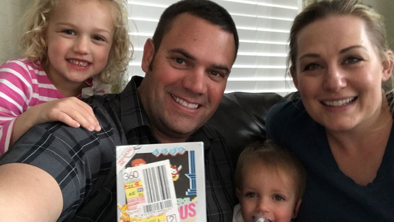 Scott Amos and his family with the "Kid Icarus" game he found in his parents' attic.