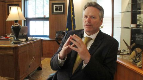 Alaska Gov. Mike Dunleavy speaks to reporters in his office at the state Capitol.