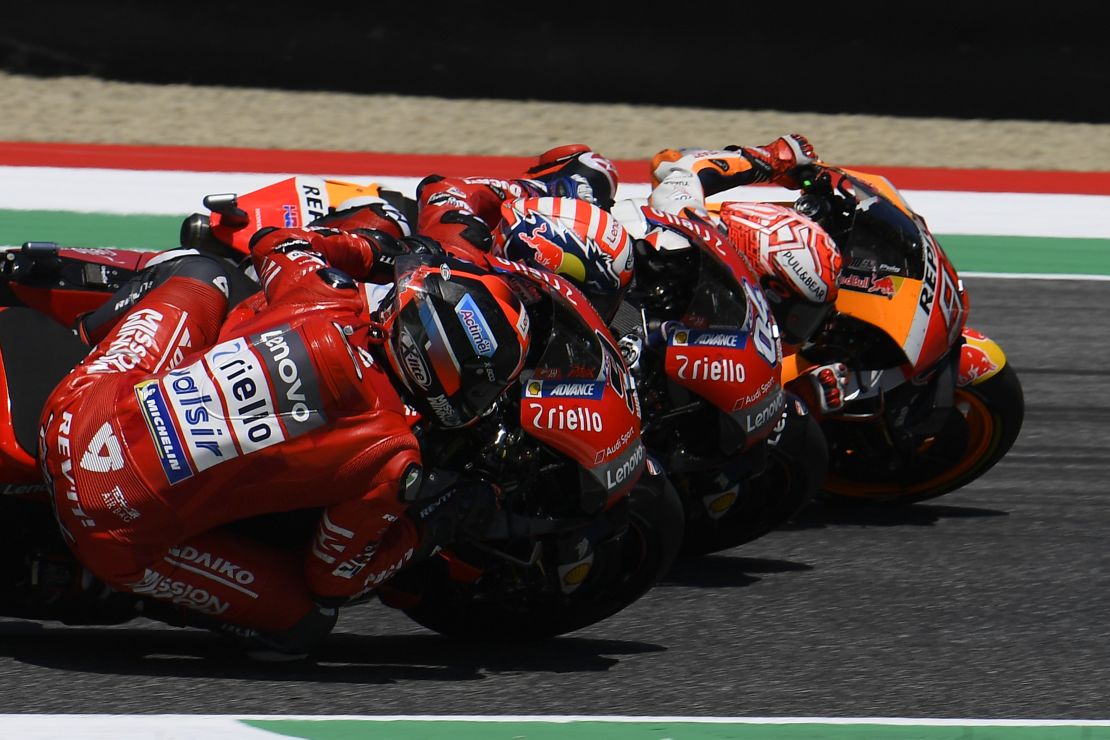 Petrucci dips under Dovizioso and Marquez to take final lap lead.