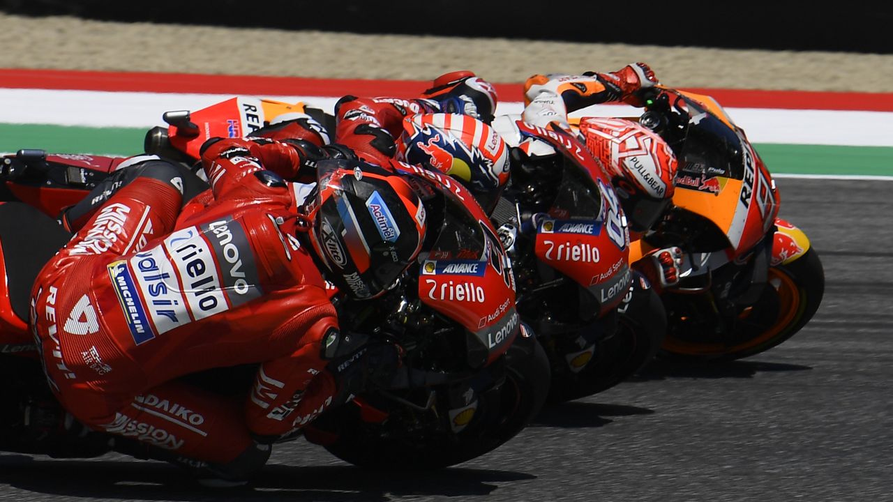 Petrucci dips under Dovizioso and Marquez to take final lap lead.