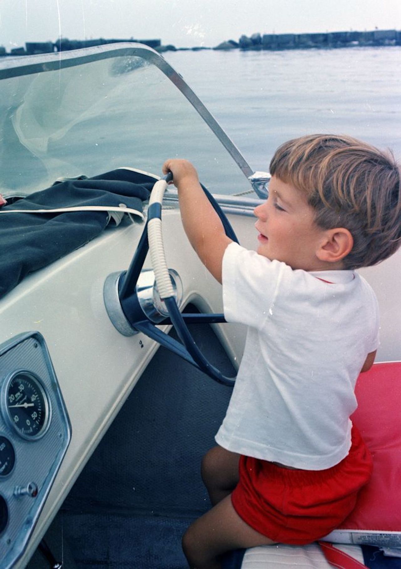 John Jr. takes the wheel of a speedboat during Labor Day weekend in 1963.